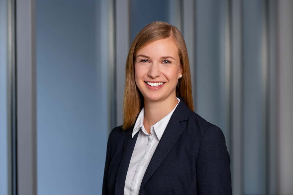 Business Portraits München, Frau vor unscharfem architektur Hintergrund