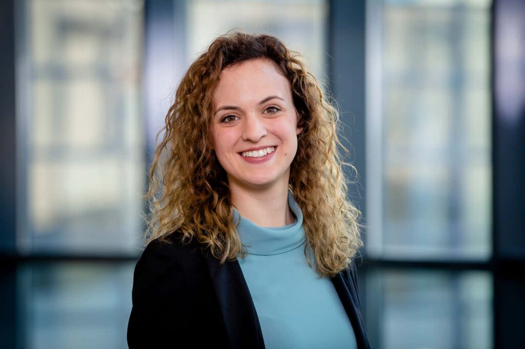 Business Portraits München, Frau vor unscharfem architektur Hintergrund