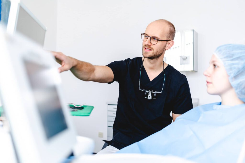 Zahnarzt während Beratungsgespräch in Behandlungszimmer, Werbefotografie Gesundheitswesen